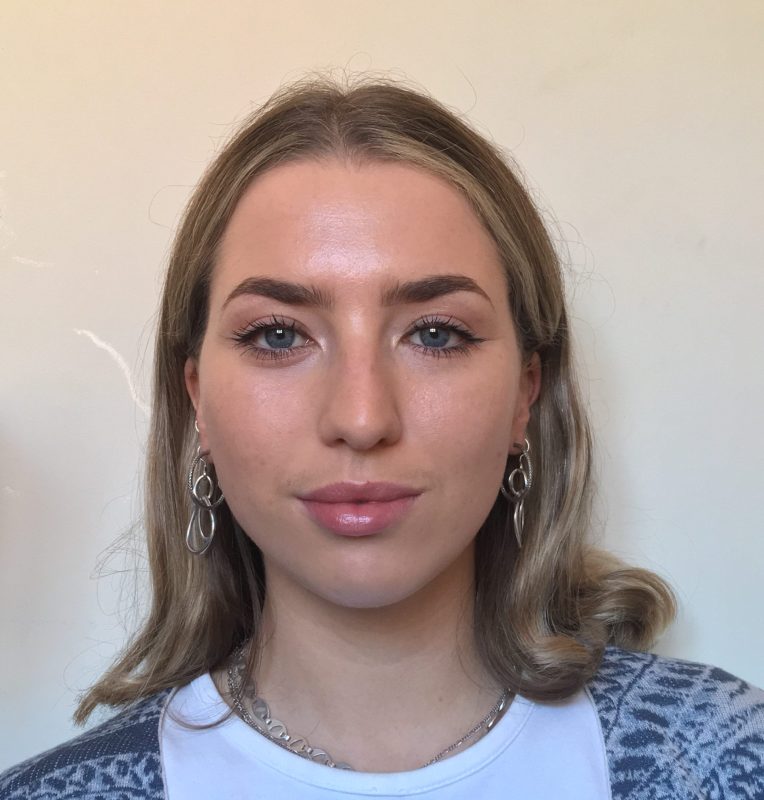 a close up photo of a young white woman with dark blonde hair and blue eyes