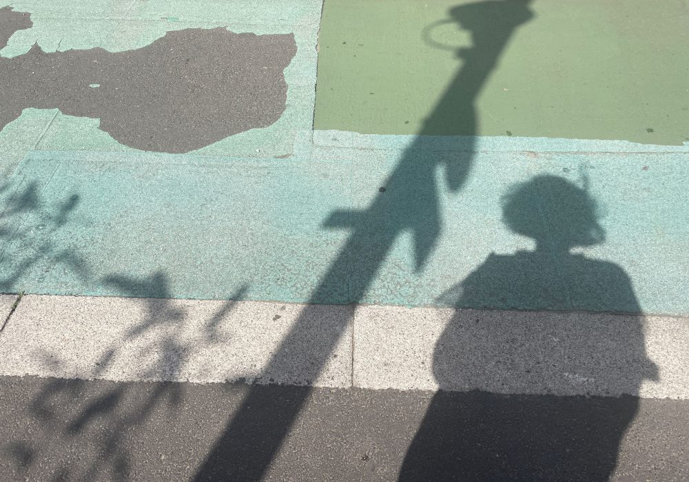 A shadow outlined against blue painted pavement