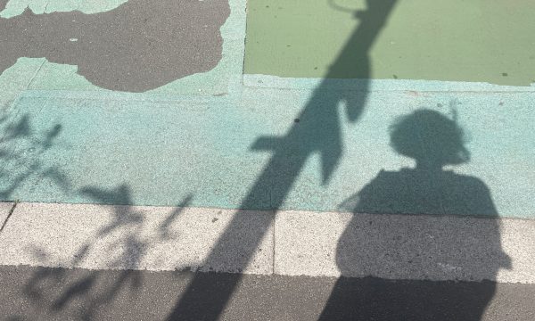 A shadow outlined against blue painted pavement