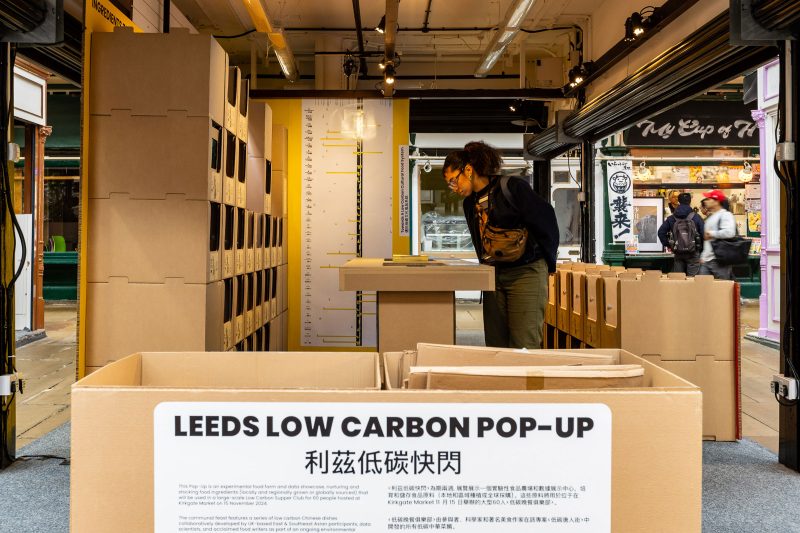 A person peers into a display titled LEEDS LOW CARBON POP UP