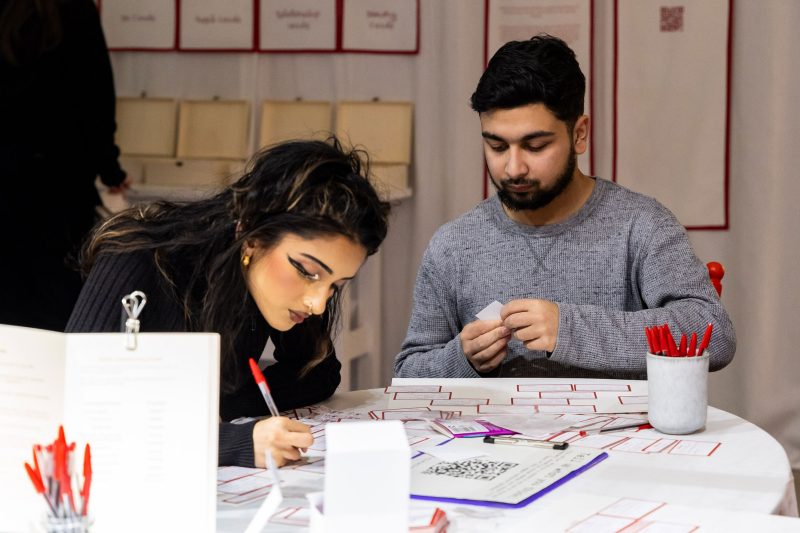 Two people at a table working on family trees