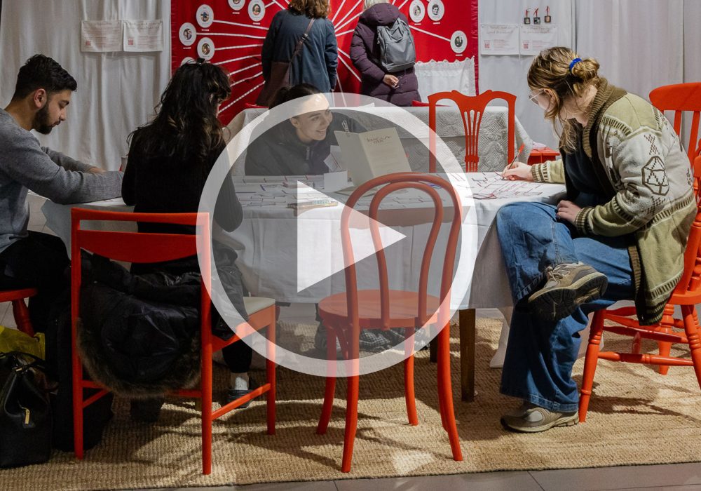 People in an exhibition with a play button over the top