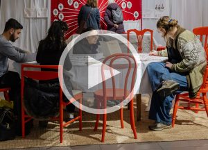 People in an exhibition with a play button over the top